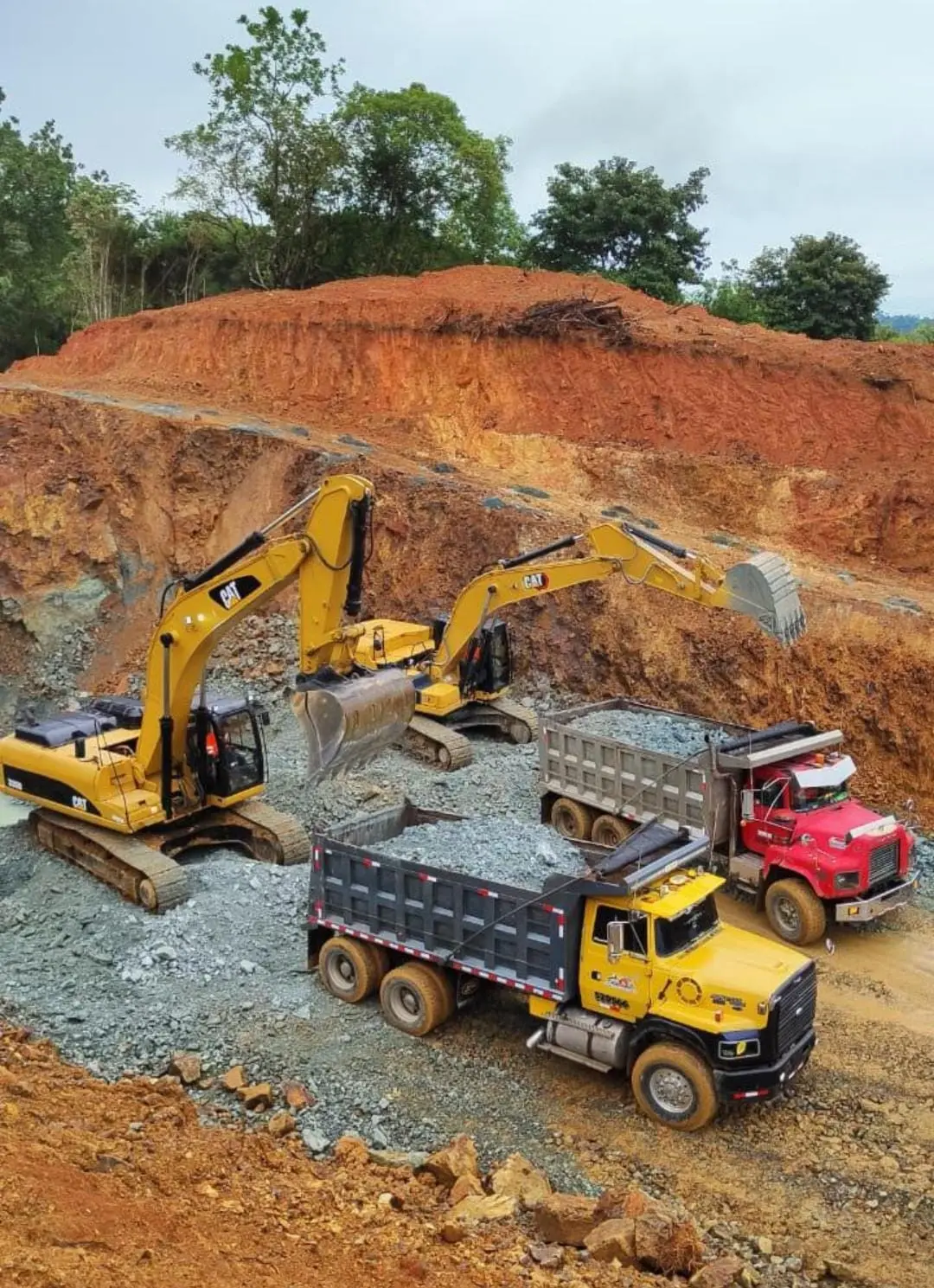 Excavadoras cargando volquetas con grava y agregados